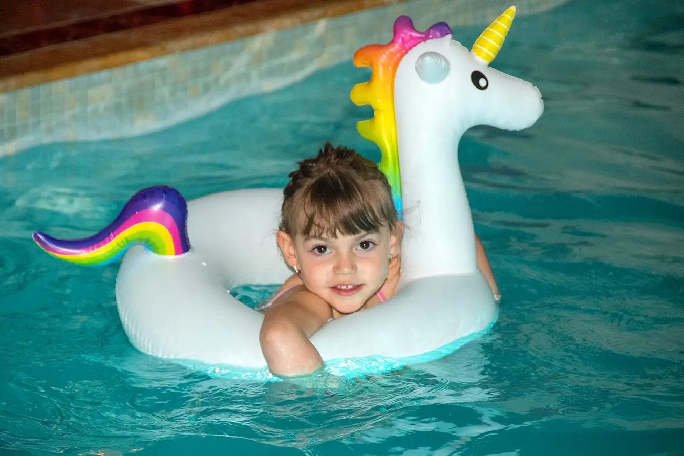 Fetiță la marginea piscinei, cu ochelari de înot
